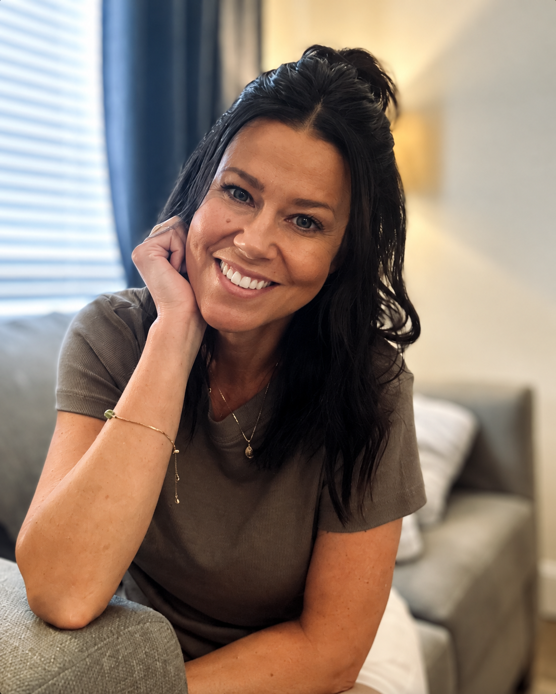 Alena Hallum smiling while seated on a couch
